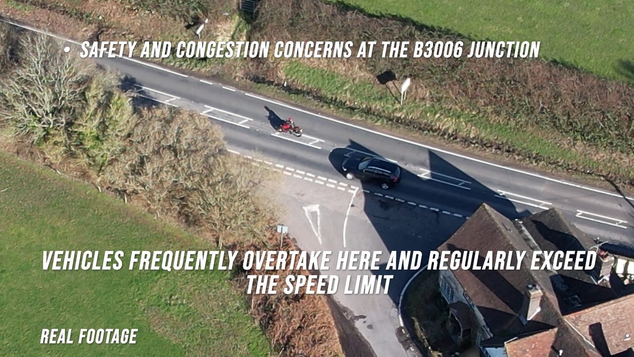 Aerial of the B3006 near the Mill Lane junction: a motorcycle and a car on the open road in a national speed limit stretch.