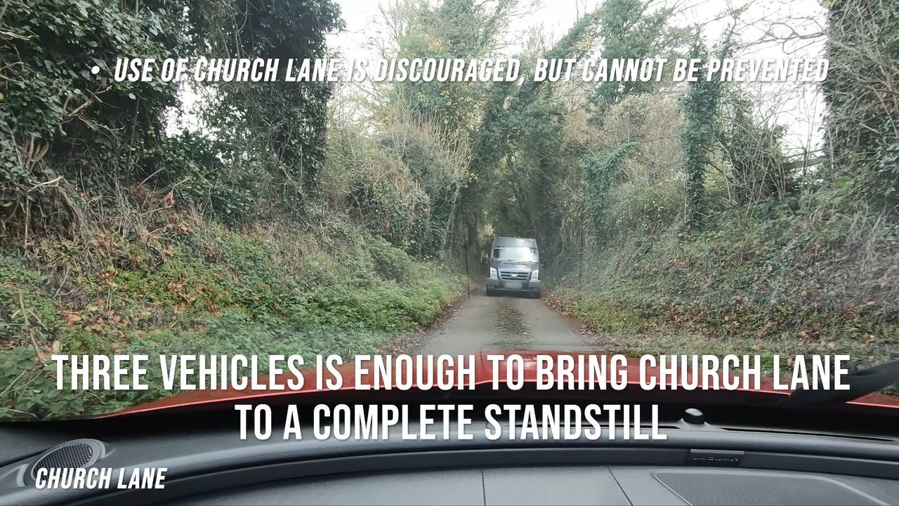 Driver's-eye view of Church Lane: a van approaching head-on on a single-track lane enclosed by high hedges, with no passing room.