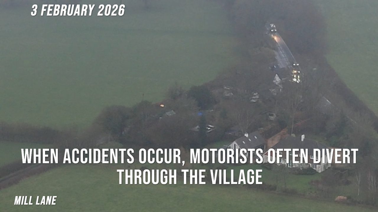 Foggy aerial of the village on 3 February 2026: dwellings along Mill Lane with traffic on the approach road beyond.