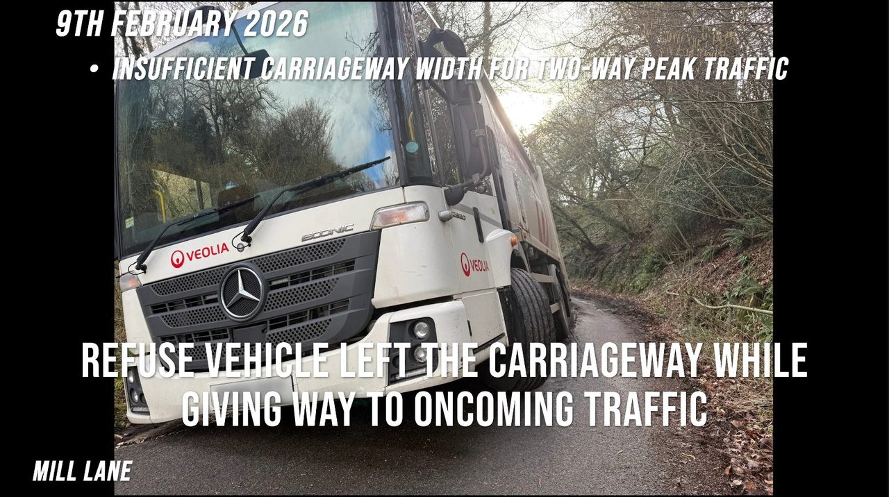 Mill Lane, 9 February 2026: a white Veolia refuse lorry tilted with its nearside wheels off the carriageway, giving way to oncoming traffic on a narrow hedged lane.